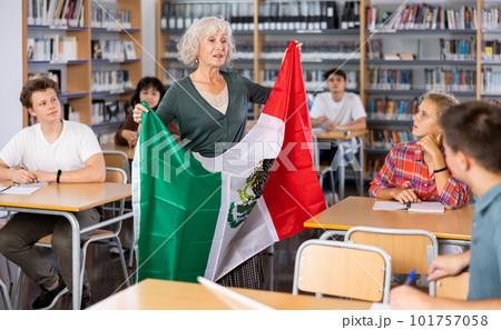 Mature female teacher shows scholchildren the national flag of Mexico 101757058