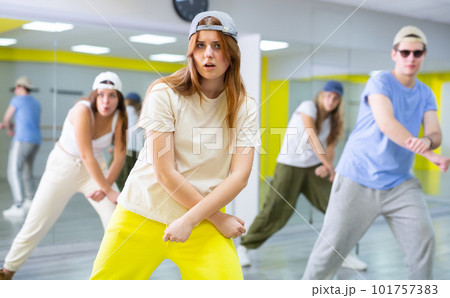 Active talented performing dance elements during lesson in modern fitness studio with mirrors Active talented performing dance elements during lesson in modern fitness studio with mirrors 101757383