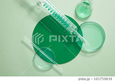 Petri dishes, test tube with spiral pipe and an erlenmeyer flask filled with green fluid. Vacant space on the plastic board to show your product Petri dishes, test tube with spiral pipe and an erlenmeyer flask filled with green fluid. Vacant space on the plastic board to show your product 101759638