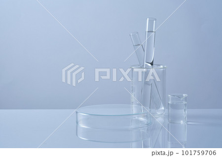 Front view of test tubes filled colorless liquid in beaker and petri dish upside down form an empty platform to display cosmetic product. Science laboratory research and development concept Front view of test tubes filled colorless liquid in beaker and petri dish upside down form an empty platform to display cosmetic product. Science laboratory research and development concept 101759706