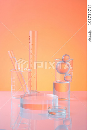 Lab theme with test tubes, beaker, petri dish and glass ball decorated on orange background. An empty transparent podium for display cosmetic product. Science and medical background Lab theme with test tubes, beaker, petri dish and glass ball decorated on orange background. An empty transparent podium for display cosmetic product. Science and medical background 101759714