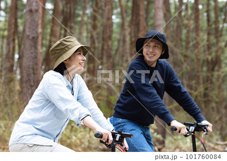 林間で電動自転車に乗るカップル 101760084