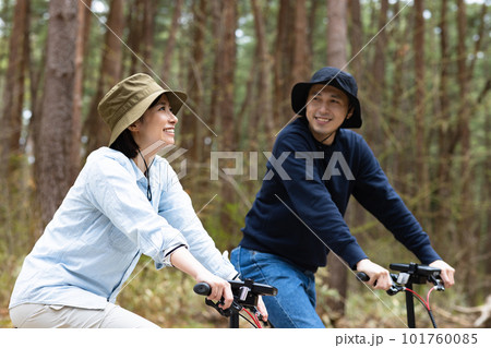 林間で電動自転車に乗るカップル 101760085