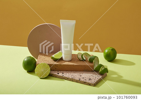 Unlabeled plastic bottles placed on rectangle brick platform, limes and limes spiraling on a yellow background. Mockup scene cosmetic, facial cleanser of limes extract Unlabeled plastic bottles placed on rectangle brick platform, limes and limes spiraling on a yellow background. Mockup scene cosmetic, facial cleanser of limes extract 101760093