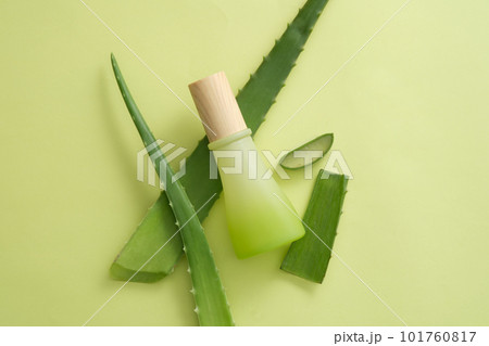 A unbranded cosmetic jar decorated with Aloe vera leaves on light background. Aloe vera (Aloe barbadensis miller) is a popular ingredient in cosmetic production 101760817
