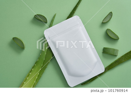 Aloe vera fresh leaves and slices with white sheet mask on white background. Mockup for cosmetic. Aloe vera gel provides water, replenishes moisture, and moisturizes the skin. 101760914