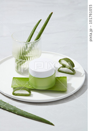 Mockup scene for cosmetic of natural extract with cream jar unlabeled and fresh aloe vera decorated on white background. Aloe vera contains many nutrients such as antioxidants, vitamins A, C, E. 101761055