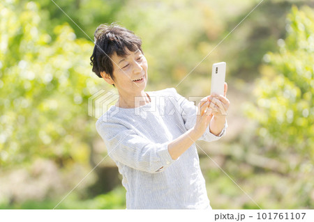 スマホを持つシニア女性のポートレート スマホを持つシニア女性のポートレート 101761107