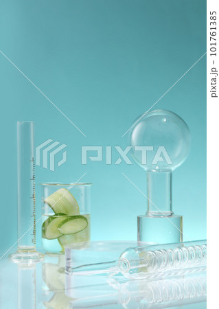 A condenser, volumetric cylinder and a beaker with Cucumber slices inside against a blue background. Cucumber (Cucumis sativus) is a source of moisture and helps the body detox A condenser, volumetric cylinder and a beaker with Cucumber slices inside against a blue background. Cucumber (Cucumis sativus) is a source of moisture and helps the body detox 101761385