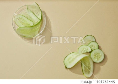 Some fresh cucumber slices arranged on beige background. Blank space for display cosmetic product of cucumber extract, which has effect of reducing sebum, helping to prevent acne from developing 101761445
