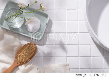 A pastel tray in rectangle shape with a flower vase and a cotton pad placed on, wooden brush with towel and wash basin displayed. Blank space for cosmetic product promotion A pastel tray in rectangle shape with a flower vase and a cotton pad placed on, wooden brush with towel and wash basin displayed. Blank space for cosmetic product promotion 101761946