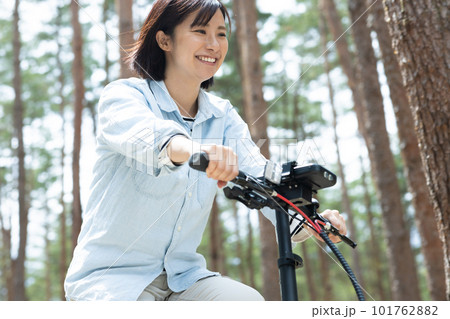 林間で電動自転車に乗る女性 101762882