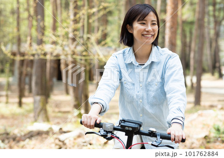 林間で電動自転車に乗る女性 101762884