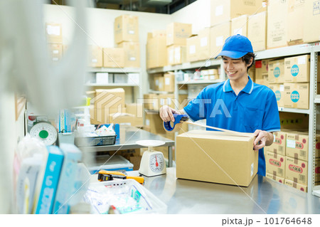 倉庫で梱包作業をする若い男性 101764648