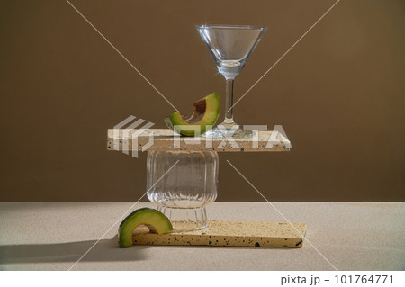 Rectangle podiums are stacked with glassware, decorated with Avocado slices. Blank space for product display. The antioxidants and vitamins in Avocado (Persea americana) oil can help heal dry skin 101764771