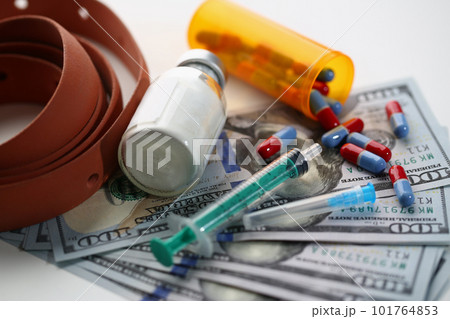 Medical syringe with white cocaine powder and medical pills on dollar bills Medical syringe with white cocaine powder and medical pills on dollar bills 101764853