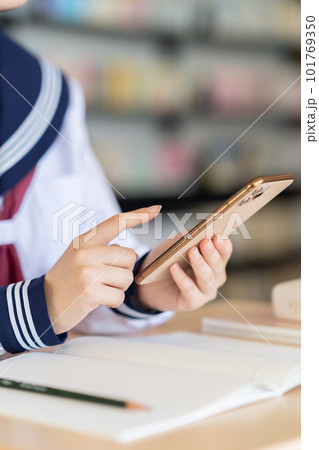 スマホを使って図書館で勉強をする女子高生のボディバーツ 撮影協力:中央工学校附属日本語学校 スマホを使って図書館で勉強をする女子高生のボディバーツ 撮影協力:中央工学校附属日本語学校 101769350