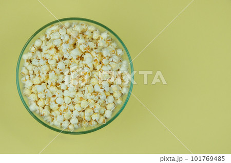 Popcorn large bowl on a yellow background. Fast food for cinema. Top view. Popcorn large bowl on a yellow background. Fast food for cinema. Top view. 101769485
