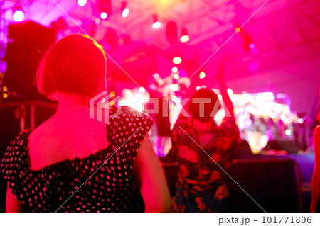 Woman dancing during concert against neon light 101771806