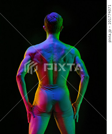 Contemporary art ballet. Young flexible athletic man, dancer posing over dark studio background with neon light. Modern style dancer. Body in glow 101774071