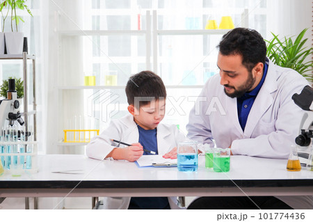 Lovely Asian young boy in lab coat enjoy doing an experiment and studying a science. Smart Asian little boy learning a science experimental with expertise scientist or science researcher in laboratory Lovely Asian young boy in lab coat enjoy doing an experiment and studying a science. Smart Asian little boy learning a science experimental with expertise scientist or science researcher in laboratory 101774436