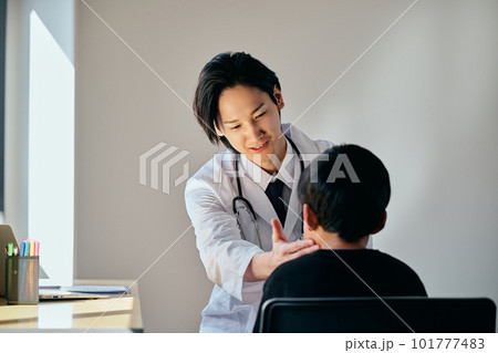 小学生の男の子を診察する若い男性医師 小学生の男の子を診察する若い男性医師 101777483
