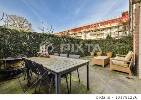an outside area with furniture and plants on the side of the building, including a table and chairs for two people an outside area with furniture and plants on the side of the building, including a table and chairs for two people 101781226