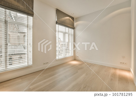 an empty room with wood flooring and white shuttered window coverings on either side of the room, there is a view an empty room with wood flooring and white shuttered window coverings on either side of the room, there is a view 101781295