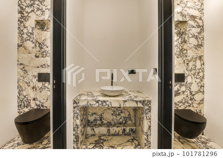 a modern bathroom with marble walls and black trim around the tub, toilet, sink and mirror in this photo 101781296
