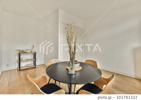 a dining table and chairs in a room with white walls, wood floors and hardwood flooring on the floor 101781322