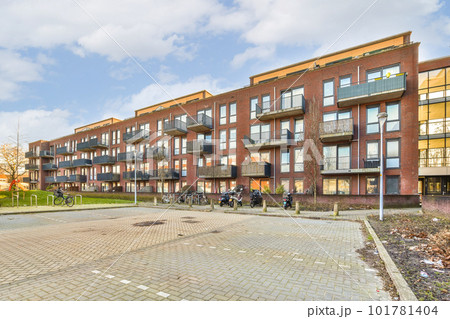 a bricked area in the middle of an apartment complex with bikes parked on the sidewalk and people walking around 101781404