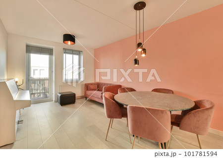 a living room with pink walls and white flooring in the center of the room is a dining table, two chairs and a a living room with pink walls and white flooring in the center of the room is a dining table, two chairs and a 101781594