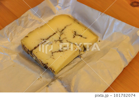 Piece of truffle cheese on a wooden table 101782074