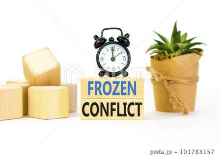 Frozen conflict symbol. Concept words Frozen conflict on beautiful wooden block. Beautiful white table white background. Black alarm clock. Business and Frozen conflict concept. Copy space. 101783157