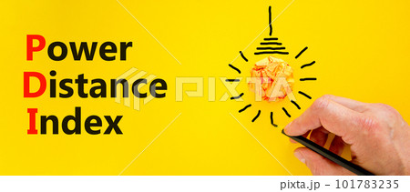 PDI power distance index symbol. Concept words PDI power distance index on yellow paper on a beautiful yellow background. Businessman hand. Business PDI power distance index concept. Copy space. 101783235