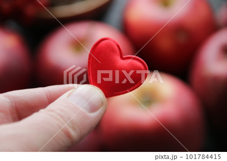 Hand holding a heart on the background of an apple healthy food concept. 101784415