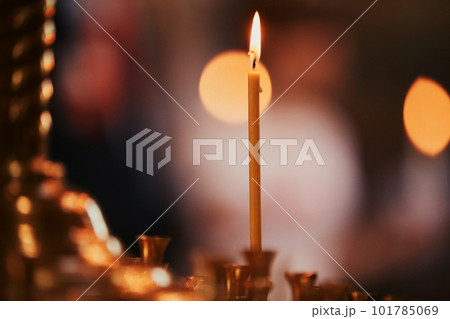 Burning candles on bronze candlestick against dark background at home.candles in the interior. Vintage style. Calm romantic atmosphere. Horizontal image for design. Burning candles on bronze candlestick against dark background at home.candles in the interior. Vintage style. Calm romantic atmosphere. Horizontal image for design. 101785069