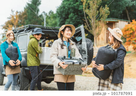 秋冬のアウトドア・キャンプ場にキャンプに来て荷物を運ぶ仲間達（男女・アジア人） 101787091