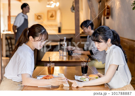 ランチを食べに来たカフェや飲食店の口コミ・SNSをスマホで見るアジア人女性 ランチを食べに来たカフェや飲食店の口コミ・SNSをスマホで見るアジア人女性 101788887