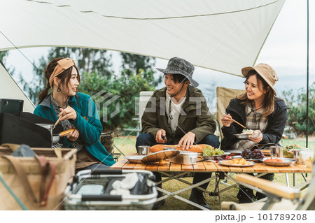秋冬のキャンプ場で料理を作るアジア人のカップルキャンパーと友達の女性 秋冬のキャンプ場で料理を作るアジア人のカップルキャンパーと友達の女性 101789208