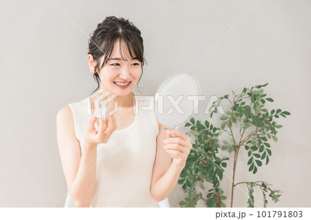 肌荒れ・ニキビが治った鏡を見る女性（ビタミン剤・サプリメント） 101791803