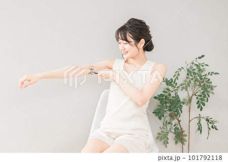 マッサージローラーで二の腕をボディケアするアジア人女性 101792118