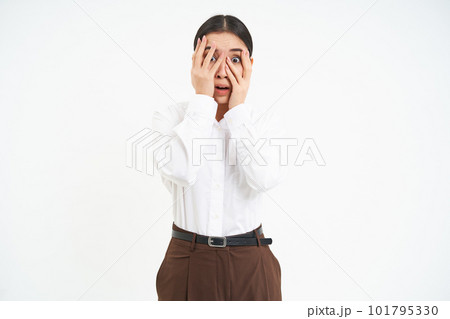 Image of young asian woman with terrified face, hides eyes behind hands and peeks through fingers with scared emotion, white background Image of young asian woman with terrified face, hides eyes behind hands and peeks through fingers with scared emotion, white background 101795330