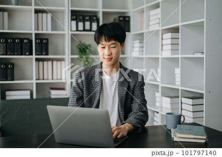 Young business man working at modern office with laptop, tablet and taking notes on the paper.. Young business man working at modern office with laptop, tablet and taking notes on the paper.. 101797140