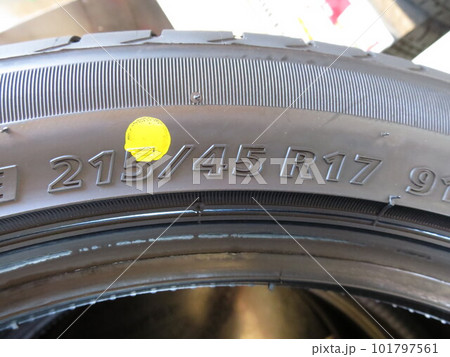 タイヤのサイドウォールに刻印されたタイヤのサイズを表す表示215/45R17と黄色の軽点 101797561