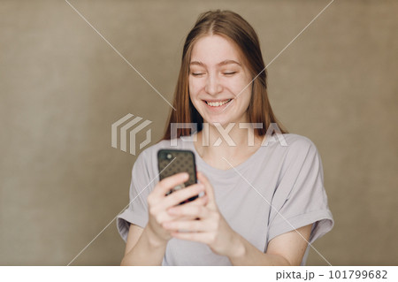 Young woman using mobile phone at brown background 101799682