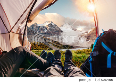 Legs of couple hiker relaxing inside a tent with Rocky Mountains view in national park 101806406