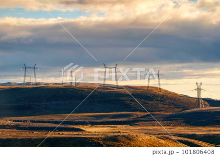 High voltage electric pole on mountain hill among remote wilderness in the sunset at Iceland 101806408