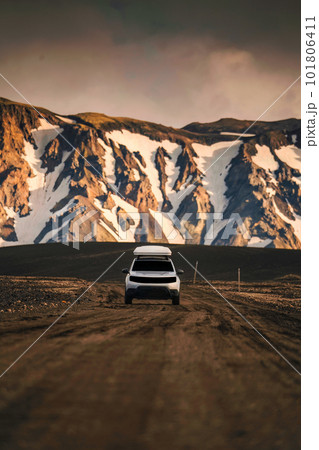 4x4 SUV car driving on dirt road and volcanic mountain background on Icelandic Highlands in summer at Landmannalaugar 101806411
