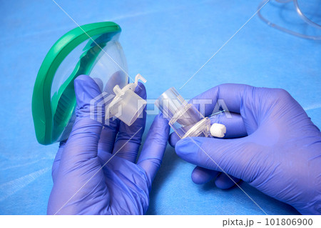 Hands in medical gloves hold an anesthesia mask Hands in medical gloves hold an anesthesia mask 101806900